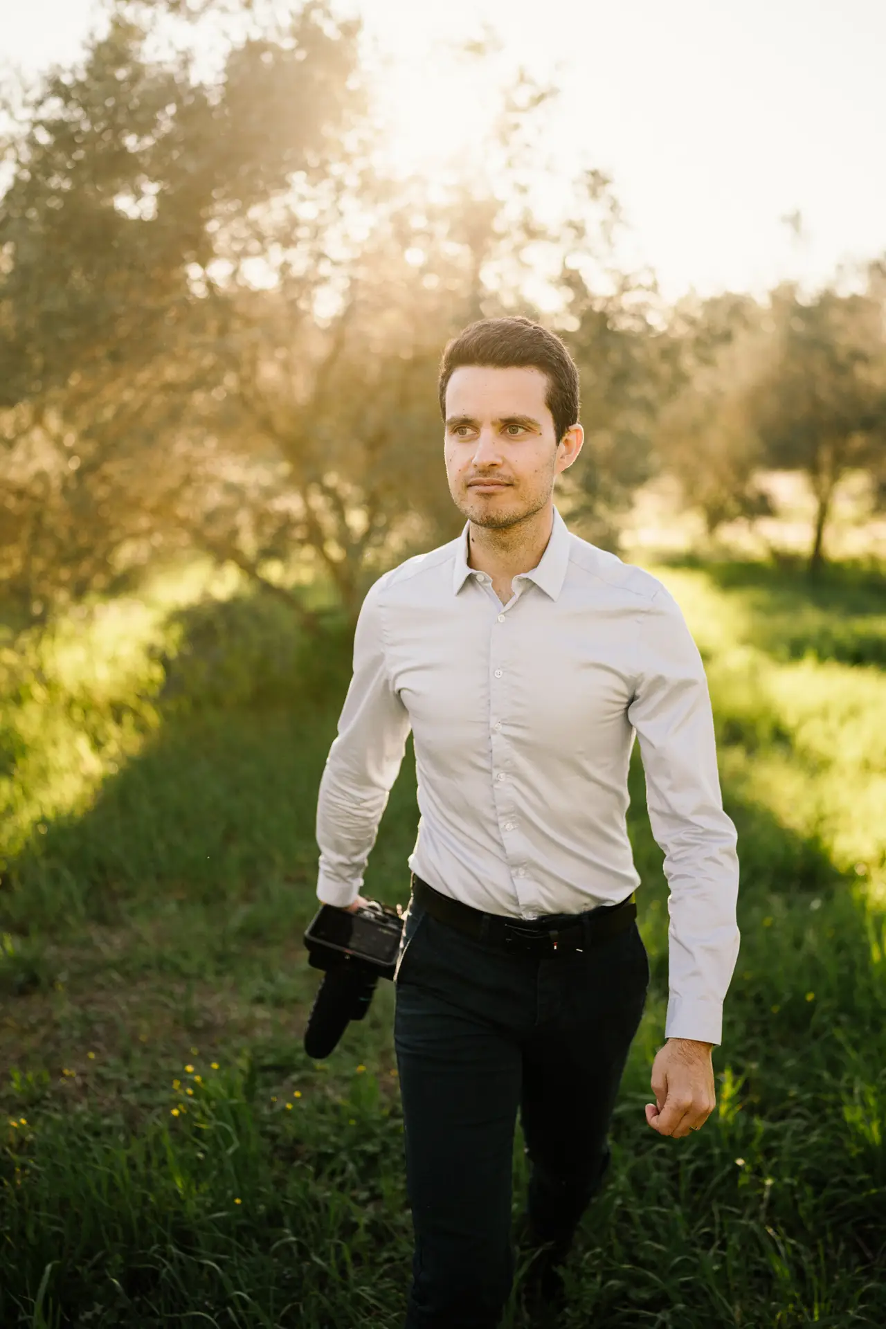 a videographer walking in a olive groves